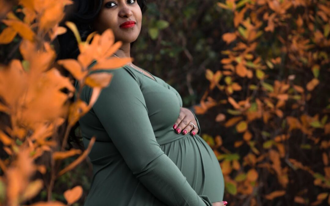 Pregnant woman with dark hair, dark skin and green dress